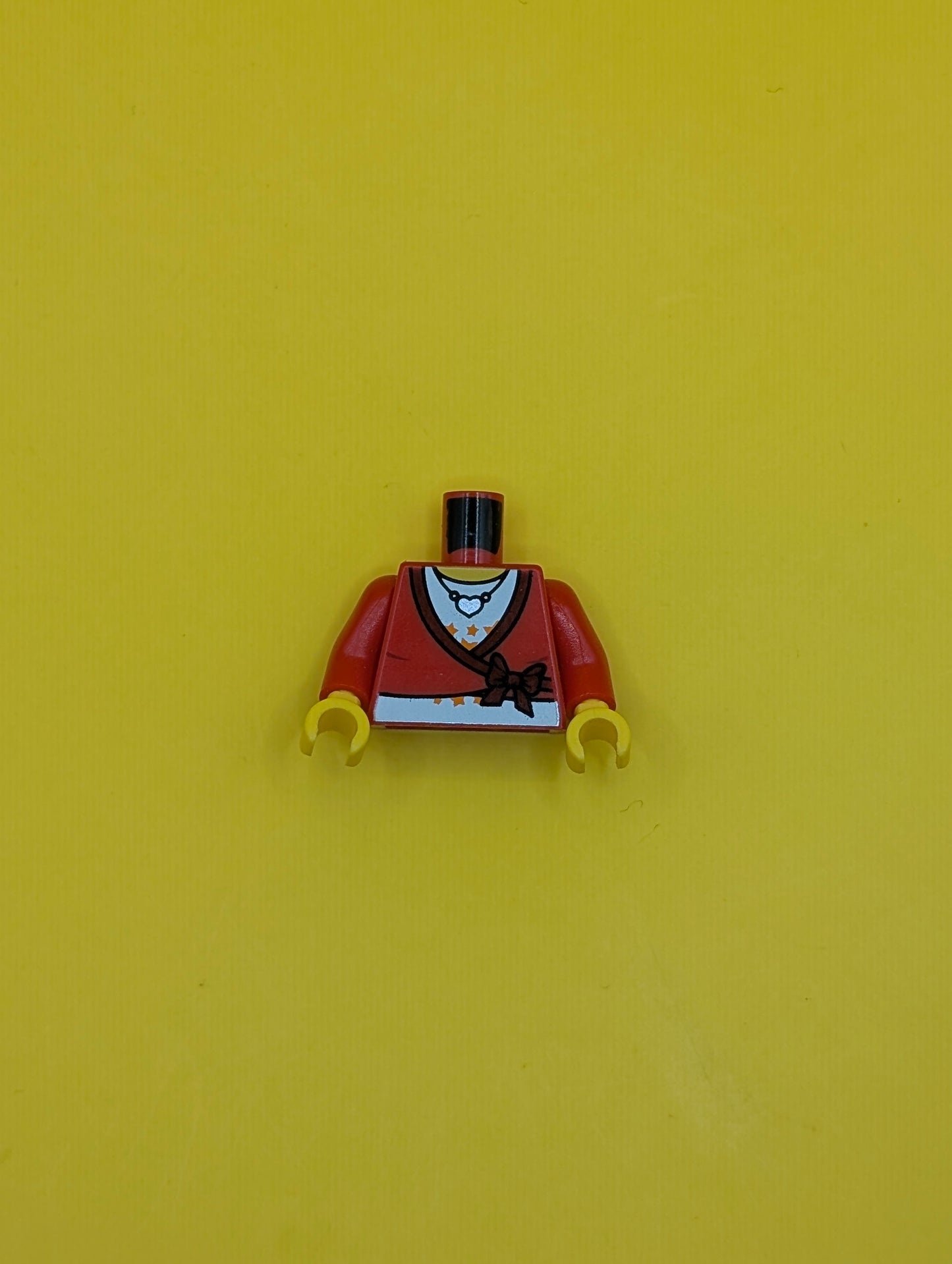 973pb0580c01 Torso Sweater Cropped with Dark Red Bow and Trim over White Shirt with Bright Light Orange Stars, Silver Heart Pendant Necklace, Yellow Neck Pattern / Red Arms / Yellow Hands Lego Part