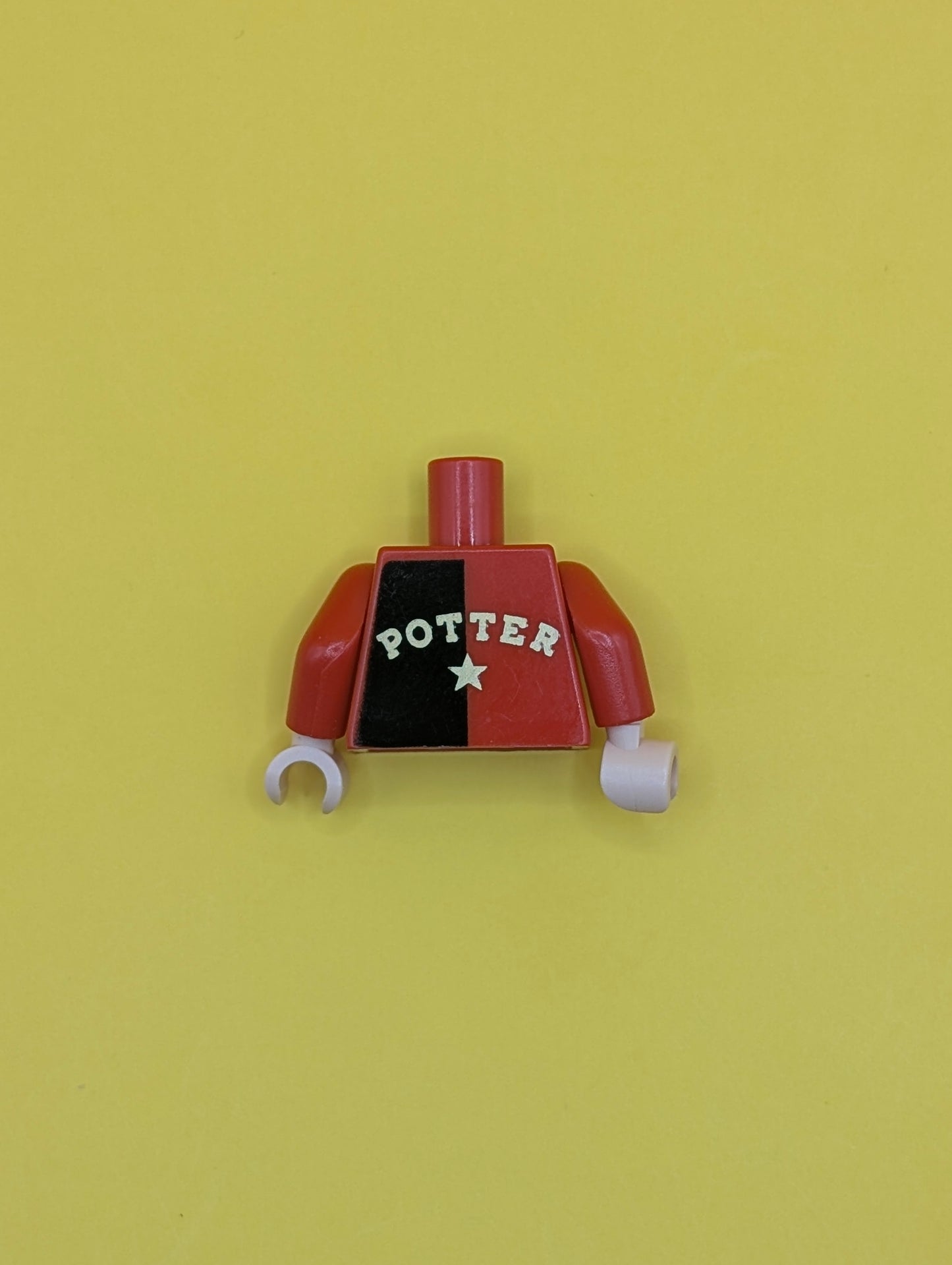Torso Shirt with Black Left Half, Hogwarts Emblem, and Gold 'POTTER' and Star on Back, Light Nougat Neck Pattern / Red Arm Left / Black Arm Right / Light Nougat Hands 973pb0331c01 Lego