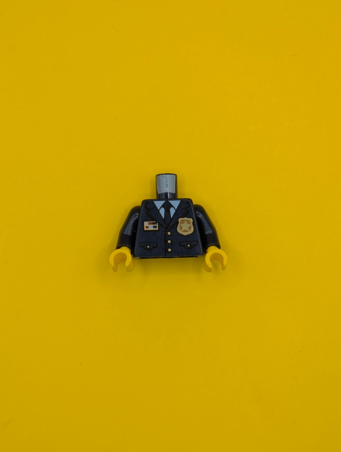 973pb3772c01 Torso Police Suit with Tie and Pockets, Gold Star Badge Logo and Buttons, Light Blue Undershirt Pattern / Dark Blue Arms / Yellow Hands Lego Part