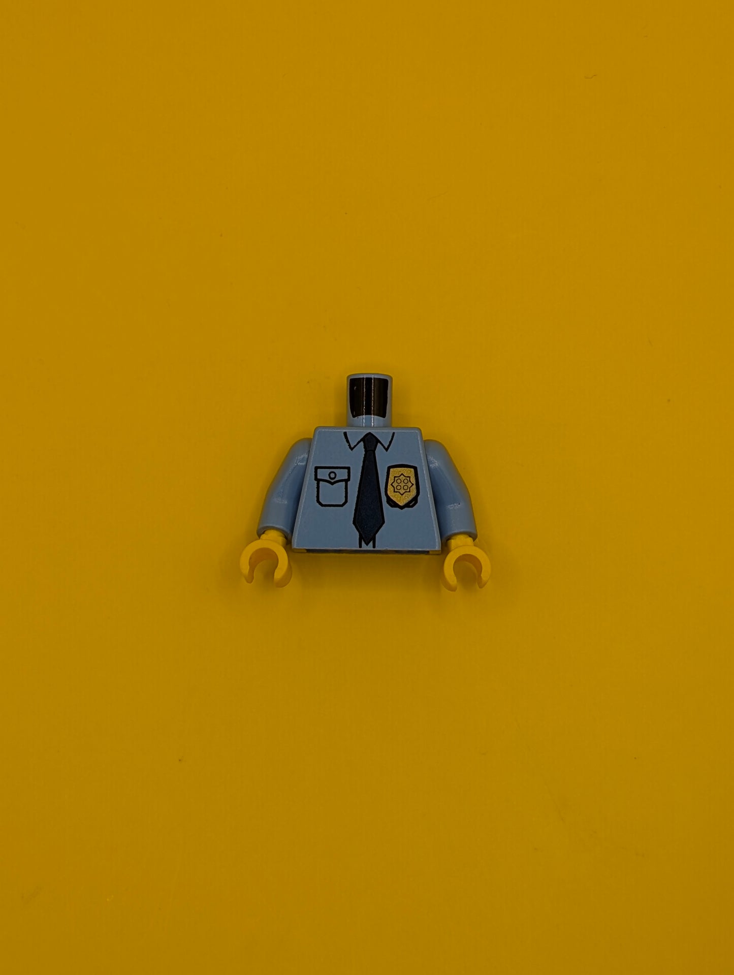 973pb0801c01 Torso Police Uniform Shirt with Pocket and White 'POLICE' on Back, Gold Badge, Dark Blue Tie Pattern / Medium Blue Arms / Yellow Hands Lego Part